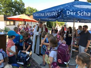 Pfarrer Dagobert Vonderau segnet Schulranzen und Kindergartentaschen